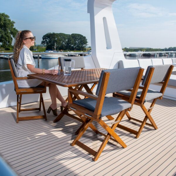 person sitting at a teak table with 4 edge chairs